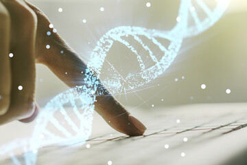 Creative concept with DNA symbol illustration and hands typing on laptop on background. Genome research concept. Multiexposure