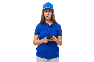 young woman promoter in a blue t-shirt and cap uses a smartphone