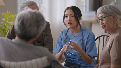 Group of asian senior people listening to young nurse. Psychological support group for elderly and lonely people in a community centre. Group therapy in session sitting in a circle in a nursing home.