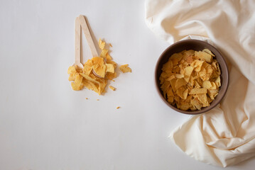 Potato chips and spoons on a white background
