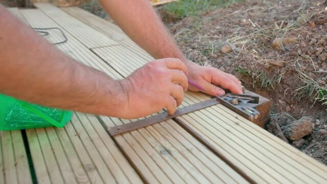 Male builder using drill to screw the screws off the timber	