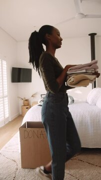 A Black Woman Folding Washing and Putting it Away