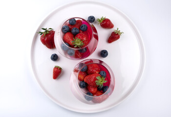 Fruit jelly dessert or panna cotta with fresh strawberries and blueberries, banner, copy space, menu, on white background