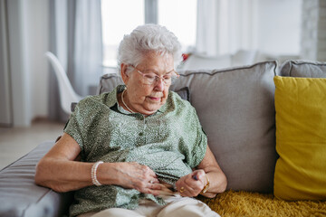 Diabetic senior patient injecting insulin in her belly.