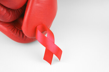 Red ribbon with boxing gloves, wrestling symbol.