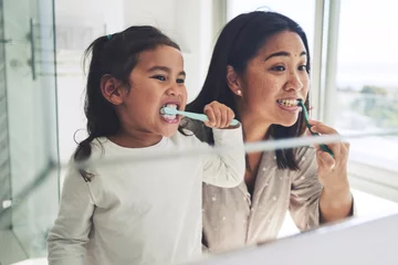 Mother, child and brushing teeth in dental cleaning hygiene, morning routine or healthcare together by mirror in bathroom. Happy mom and daughter mouth in tooth whitening, oral or gum care at home