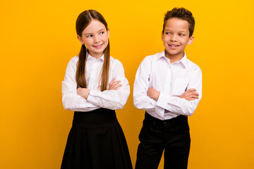 Photo of funky tricky preteen schoolkids dressed white shirts arms folded looking each other isolated yellow color background