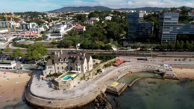 Aerial drone view of train approaching Cascais train station close to the sea promenade