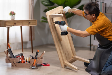 Worker repair wooden drawer of cabinet in living room.