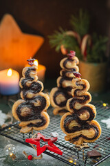 Christmas tree cinnamon cookies with decor on a black lattice on a green concrete background. Christmas sweets.