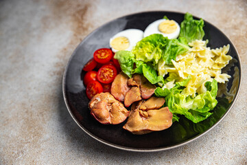 chicken liver salad tomato, green leaf lettuce, boiled egg, farfalle pasta pasta salad ready to eat healthy meal food snack on the table copy space food background rustic top view