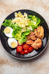chicken liver salad tomato, green leaf lettuce, boiled egg, farfalle pasta pasta salad ready to eat healthy meal food snack on the table copy space food background rustic top view