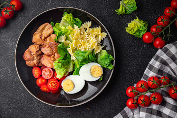 chicken liver salad tomato, green leaf lettuce, boiled egg, farfalle pasta pasta salad ready to eat healthy meal food snack on the table copy space food background rustic top view