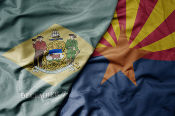 big waving colorful national flag of arizona state and flag of delaware state .