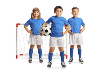Two boys and a girl in football jerseys posing in front of a mini goal