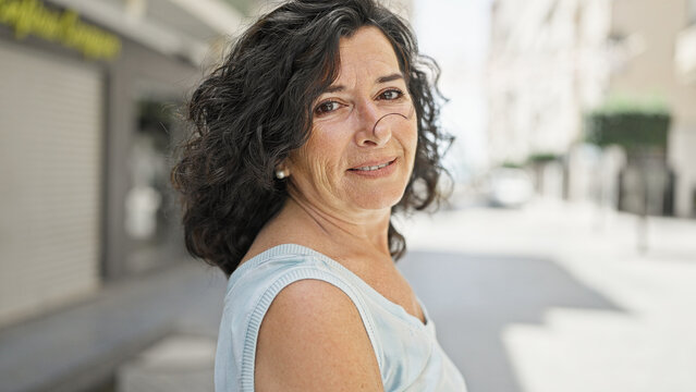 Middle age hispanic woman smiling confident standing at street