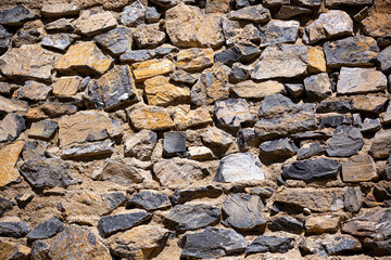 Stone antique old wall as a background or texture. Vintage background of a fortress wall in loft and grunge style with place for text and copy space.