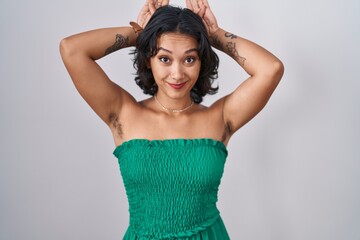 Young hispanic woman standing over isolated background doing bunny ears gesture with hands palms looking cynical and skeptical. easter rabbit concept.