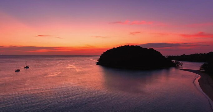 .aerial view amazing pink sky of sunset above Kala island at Layan beach Phuket..The reflection of sky on the ocean waters creates a stunning background.gradient colors. Kala island background..