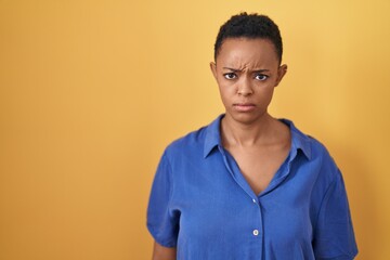 African american woman standing over yellow background skeptic and nervous, frowning upset because of problem. negative person.