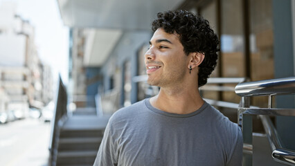 Young latin man smiling confident looking to the side at street