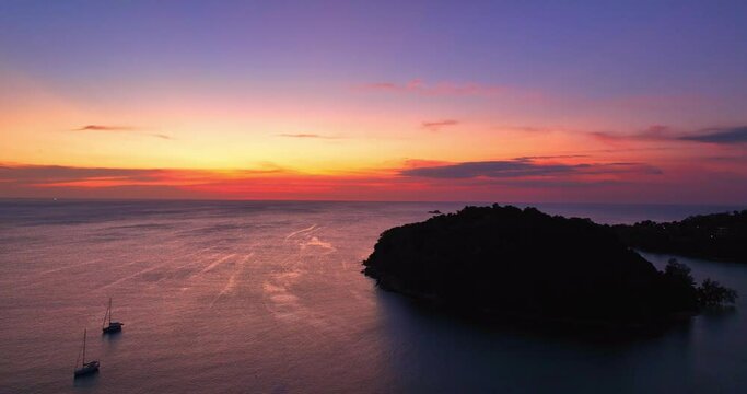 .aerial view amazing pink sky of sunset above Kala island at Layan beach Phuket..The reflection of sky on the ocean waters creates a stunning background.gradient colors. Kala island background..