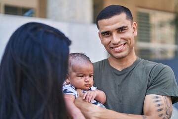 Hispanic family smiling confident hugging each other at street