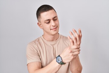 Young man standing over isolated background suffering pain on hands and fingers, arthritis inflammation