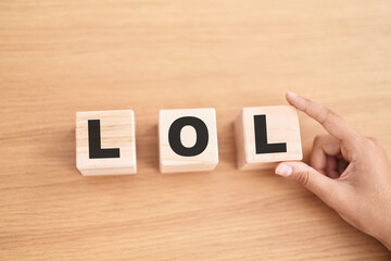 Woman hand holding cubes with lol word on the table