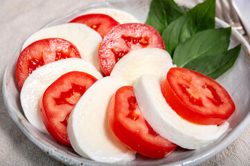 Itaian vegetarian food, fresh caprese salad made with white soft italian mozzarella cheese, red tomato and green basil with olive oil