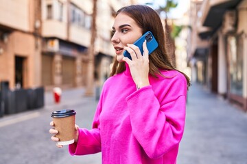 Young woman talking on the smartphone drinking coffee at street