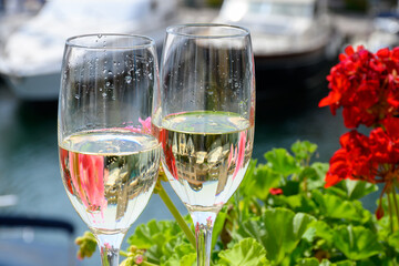 Drinking of French brut champagne sparkling wine in glasses, club party in yacht harbour of Port Grimaud near Saint-Tropez, French Riviera vacation, France