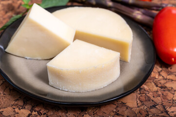 Italian cheese, Provolone dolce cow cheese from Cremona served with olive bread and tomatoes close up