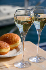 Drinking of French brut champagne sparkling wine with sweet apple Beignet, club party in yacht harbour of Port Grimaud near Saint-Tropez, French Riviera vacation, France