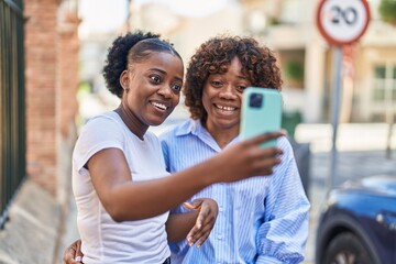 African american women mother and daughter make selfie by smartphone at street