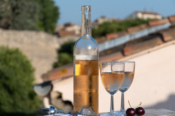 French cold rose dry wine from Provence in two glasses in sunny day with view on old roofs of Arles town in sunny day