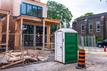 Gordijnen on site toilet facility outside the fencing at a residential construction site shot in summer in toronto © Michael Connor Photo