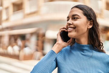 Young african american woman smiling confident talking on the smartphone at street