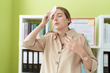 Young caucasian woman business worker using napkin sweating at office