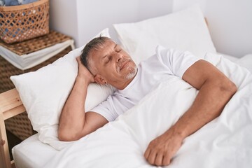 Middle age grey-haired man lying on bed sleeping at bedroom