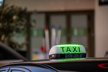 Close-up of taxi sign on car at the airport - obrazy, fototapety, plakaty