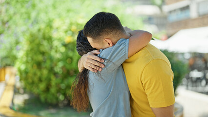 Man and woman couple hugging each other at park