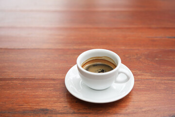 small white coffee cup on red wooden table
