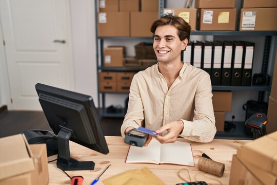 Young caucasian man ecommerce business worker using data phone and credit card at office