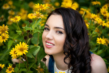 portrait of beautiful brunette smiling woman with yellow flowers