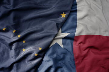 big waving colorful national flag of texas state and flag of alaska state .