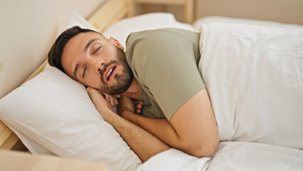 Young hispanic man lying on bed sleeping at bedroom