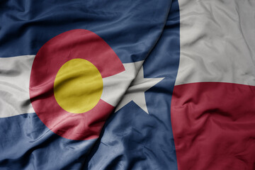 big waving colorful national flag of texas state and flag of colorado state .