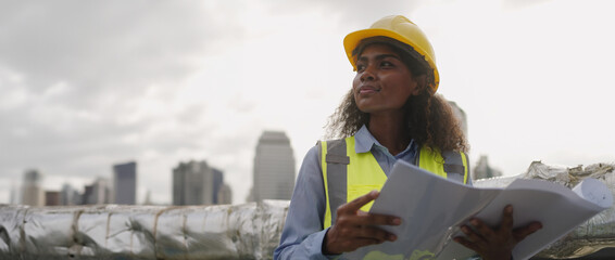 Civil engineer woman dark skin wearing uniform and safety helmet under inspection and checking plan on factory plant station by tablet.Civil Engineer,Industry,construction,Industry maintenance concept