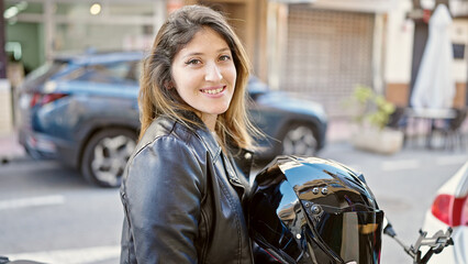Young blonde woman smiling confident sitting on motorcycle at street